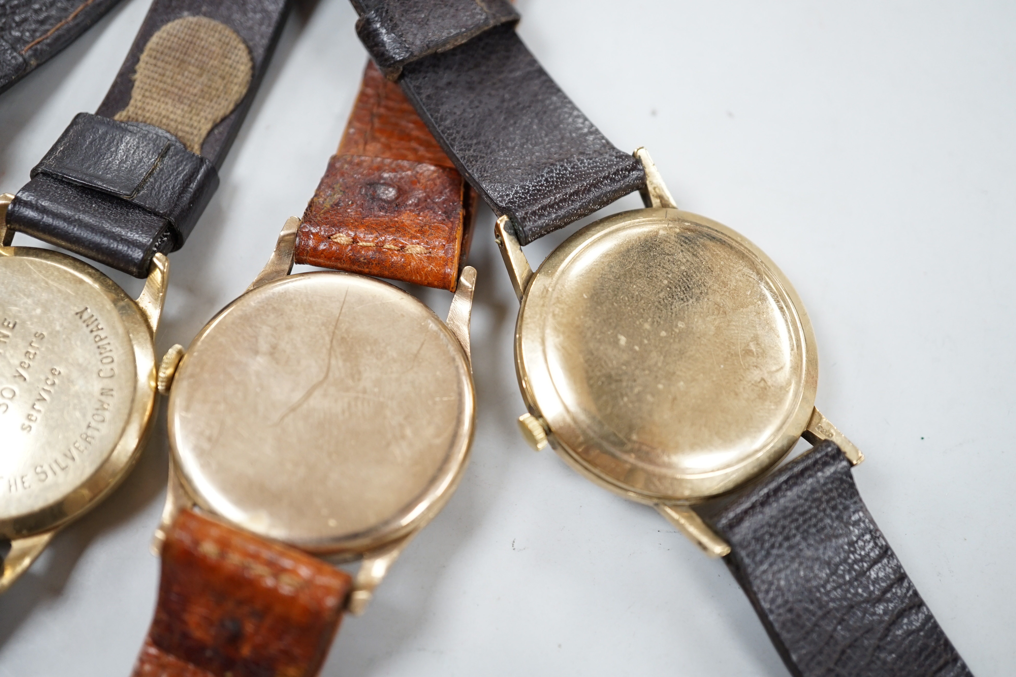 Two gentleman's 9ct gold manual wind wrist watches, retailed by Garrards, both with engraved inscription and two other 9ct gold wrist watches including Eterna.